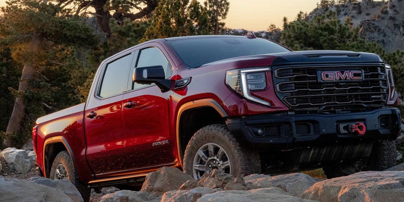 Red GMC Sierra 1500 navigating Natchez, MS over rocky terrain off-road